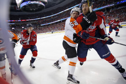 Philadelphia Flyers center Nick Cousins (52) and Washington Capitals defenseman Brooks Orpik collide during the first period of Game 1 of a first-round NHL hockey Stanley Cup playoff series Thursday, April 14, 2016, in Washington. Orpik received a two-minute penalty on the play. (AP Photo/Alex Brandon)