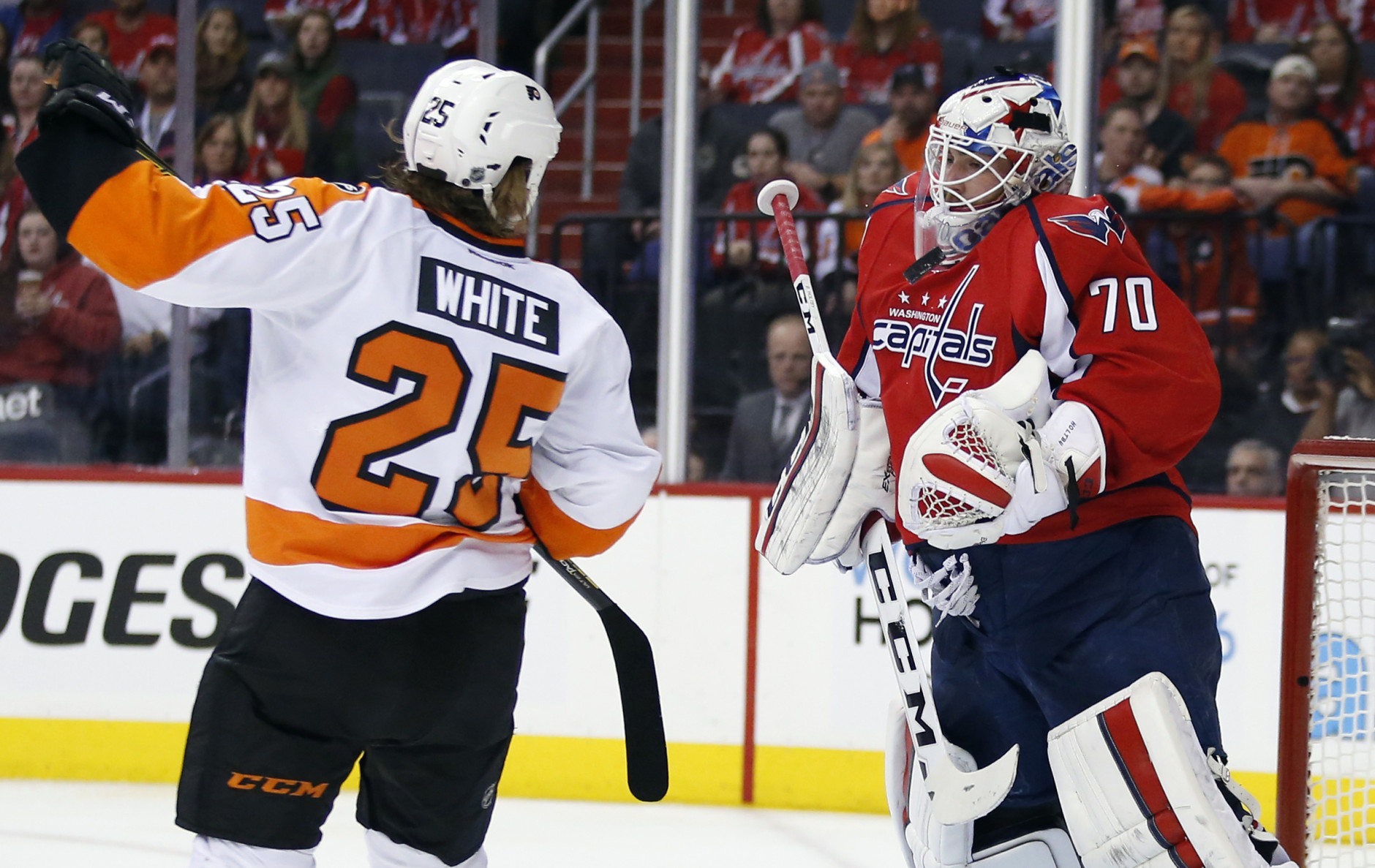 Washington Capitals goalie Braden Holtby (70) blocks a shot with Philadelphia Flyers center Ryan White (25) nearby during the first period of Game 1 of a first-round NHL hockey Stanley Cup playoff series Thursday, April 14, 2016, in Washington. (AP Photo/Alex Brandon)