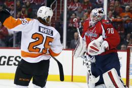 Washington Capitals goalie Braden Holtby (70) blocks a shot with Philadelphia Flyers center Ryan White (25) nearby during the first period of Game 1 of a first-round NHL hockey Stanley Cup playoff series Thursday, April 14, 2016, in Washington. (AP Photo/Alex Brandon)