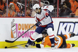 Washington Capitals' Justin Williams, left, and Philadelphia Flyers' Michael Raffl battle for the puck during the first period of Game 6 in the first round of the NHL Stanley Cup hockey playoffs, Sunday, April 24, 2016, in Philadelphia. (AP Photo/Matt Slocum)