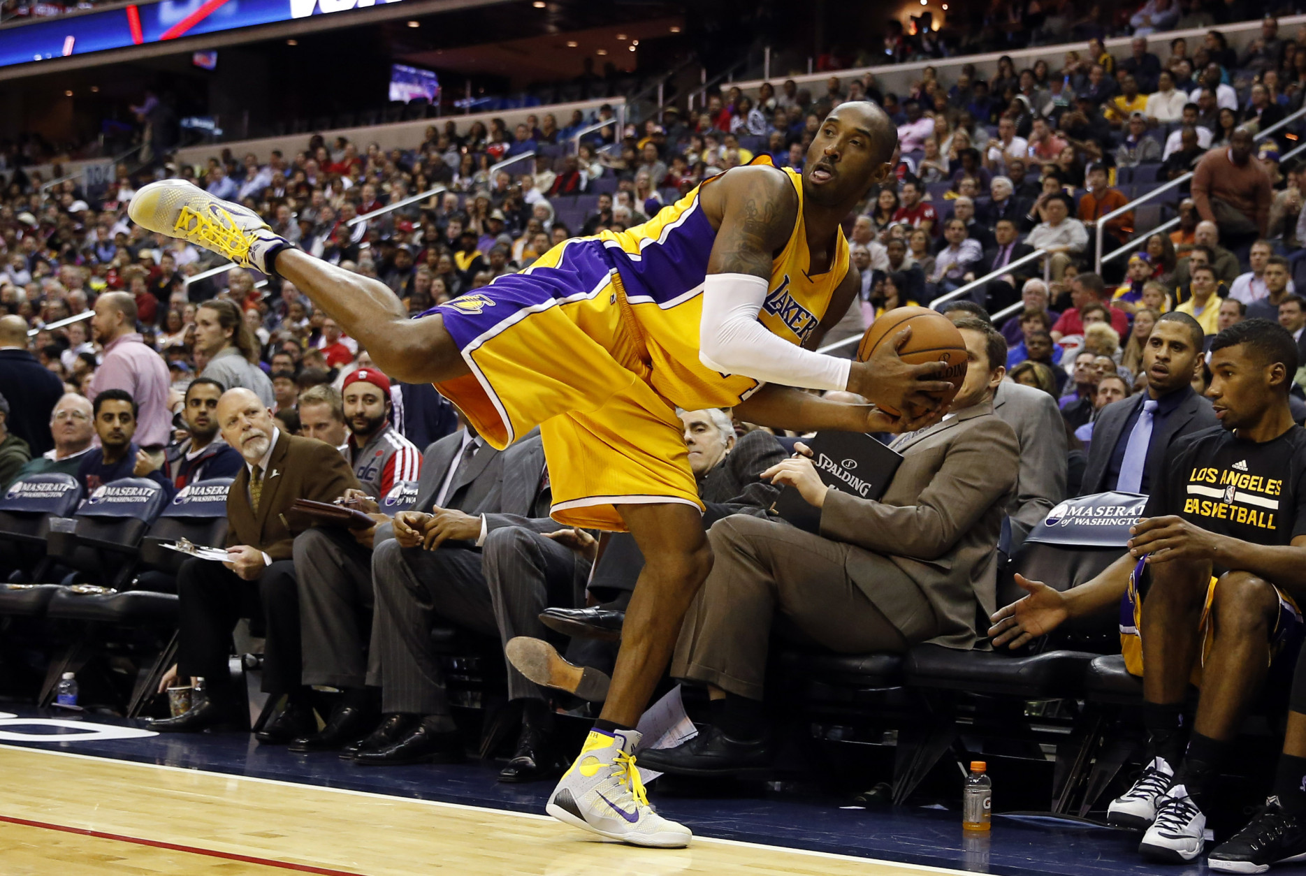 Los Angeles Lakers guard Kobe Bryant (24) balances on one foot as he saves the ball from going out of bounds in the second half of an NBA basketball game against the Washington Wizards, Wednesday, Dec. 3, 2014, in Washington. The Wizards won 111-95. (AP Photo/Alex Brandon)