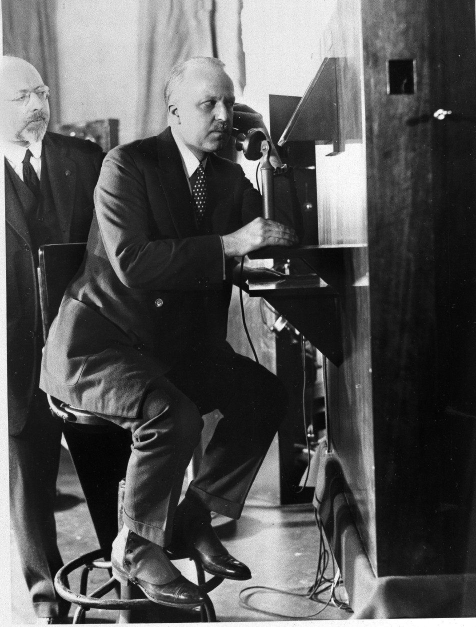 F.B. Jewett, president of A.T.&amp;T. Co. in New York, talks with Secretary Hoover in Washington as he views Hoover's moving image in the small box at eye level, April 8, 1927.  Dr. Herbert E. Ives, who is credited with the invention, looks on.  (AP Photo)