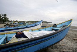 A man, his home destroyed by a 7.8 magnitude earthquake, sleeps in his uncle's boat docked along the shore, in La Chorrera, Ecuador, Monday, April 18, 2016. The Saturday night quake left a trail of ruin along Ecuadors normally placid Pacific Ocean coast. At least 350 people died and thousands are homeless. President Rafael Correa said early Monday that the death toll would surely rise, and in a considerable way. (AP Photo/Dolores Ochoa)