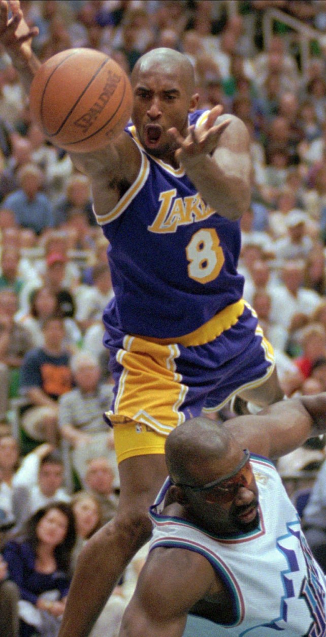 FILE - In this May 12, 1997 file photo, Los Angeles Lakers guard Kobe Bryant (8) reacts to losing the ball as Utah Jazz forward Antoine Carr hits the deck in the fourth quarter of an NBA basketball game in Salt Lake City.  The Jazz beat the Lakers 98-93 in overtime. Bryant badly missed four shots in the final moments of the playoff loss to the Utah Jazz, ending the Lakers season. When the team returned to Los Angeles that night, Bryant went to a suburban gym and worked on his shot until dawn. Today, he says the Airball Game was a turning point in his ability to handle negativity and self-doubt with hard work.  (AP Photo/Douglas C. Pizac, File)