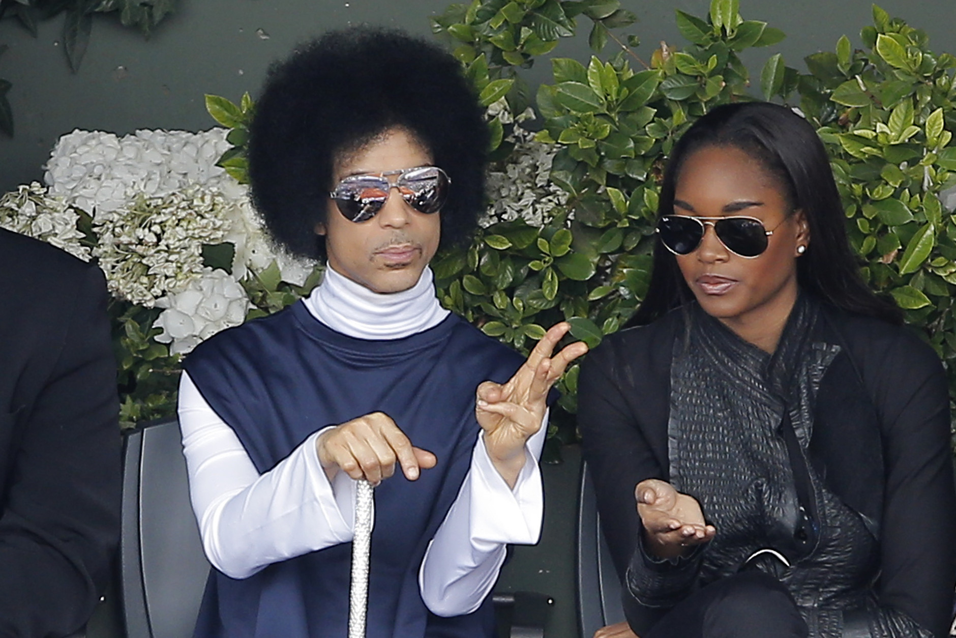 U.S. pop singer Prince, left, watches the fourth round match of the French Open tennis tournament between Spain's Rafael Nadal and Serbia's Dusan Lajovic at the Roland Garros stadium, in Paris, France, Monday, June 2, 2014. (AP Photo/Michel Spingler)