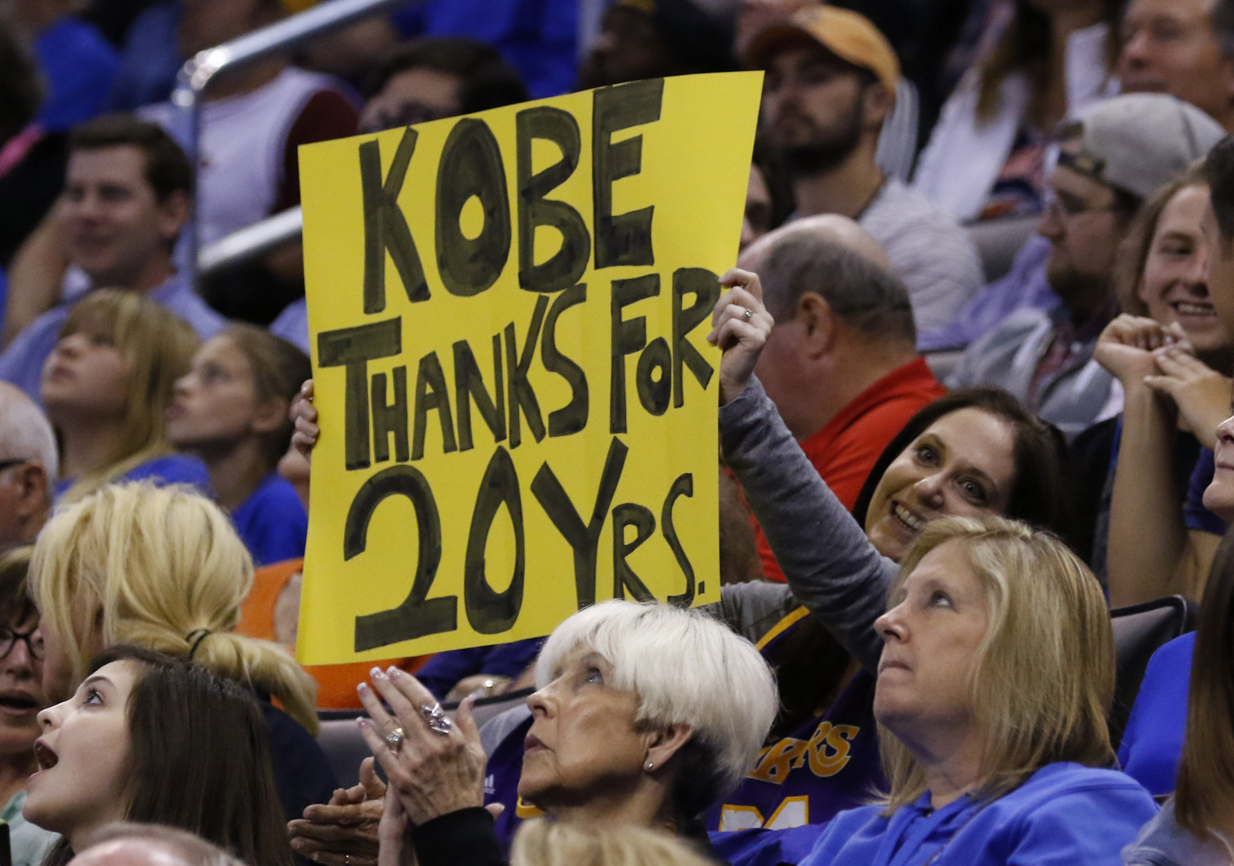 A Kobe Bryant fan holds a sign thanking him for his 20 years during the first half of an NBA basketball game in Oklahoma City, Monday, April 11, 2016. (AP Photo/Alonzo Adams)