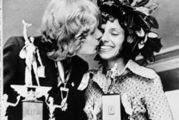 Olavi Suomalainen of Finland, winner of the men's division of the Boston A.A. Marathon April 17, 1972, kisses Nina Kuscsik of Long Island, N.Y., winner of the women's division, at the trophy presentation April 18, 1972. The finish runner won the Hopkinton to Boston marathon 26 mile, 386 yard in two hours, 15 minutes and 30 seconds. Nina's time was three hours, 10 minutes, 58 seconds. (AP Photo)