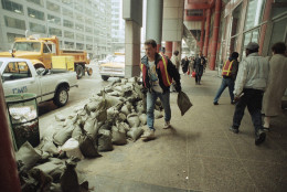 Workmen carry sandbags outside the State of Illinois building in Chicago after basements of buildings in the downtown area were flooded, April 14, 1992.  A system of tunnels in the area filled with water from the Chicago River after a leak developed.  (AP Photo/Mike Fisher)