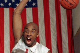 FILE--With a large flag as a backdrop, Kobe Bryant dunks the ball at his Lower Merion, Pa. high school gym during a practice Friday, Jan. 19, 1996. Bryant was chosen by the Charlotte Hornets in the first round of the NBA draft Wednesday June 26, 1996 (AP Photo/rusty kennedy)