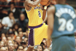 Los Angeles Lakers Kobe Bryant looks for a teammate to pass to as Minnesota Timberwolves James Robinson looks on during their game at the Forum in Inglewood, California on Sunday, Nov. 3, 1996. (AP Photo/Michael Caulfield)