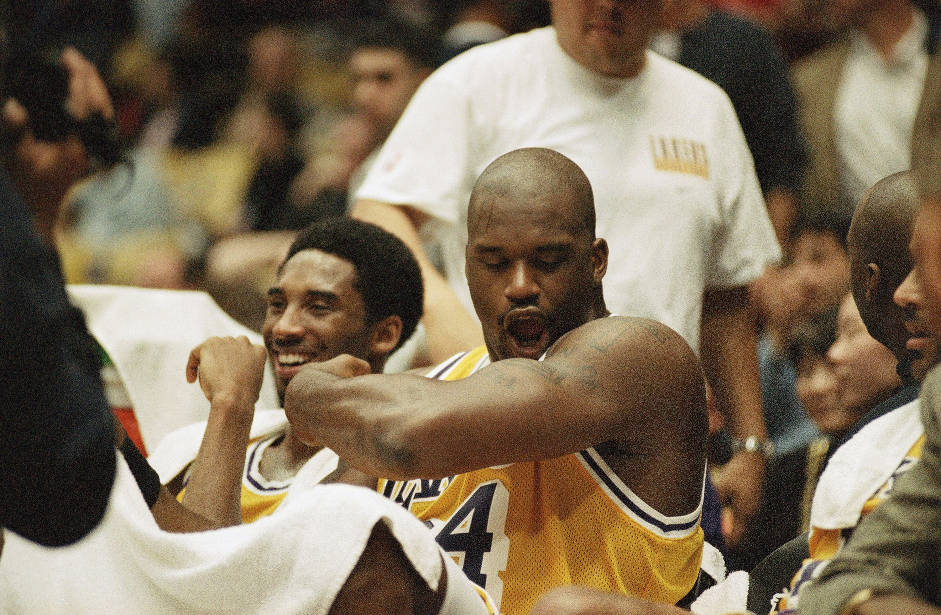 Los Angeles Lakers Shaquille O?Neal, right, flex his arm as he polishes off his superman tattoo seated next to teammate Kobe Bryant during the fourth quarter of their blowout game against the Chicago Bulls, Feb. 1, 1998 in Inglewood, California. O?Neal scored 24-points and Bryant scored 20-points to route the Bulls, 112-87. (AP Photo/Kevork Djansezian)