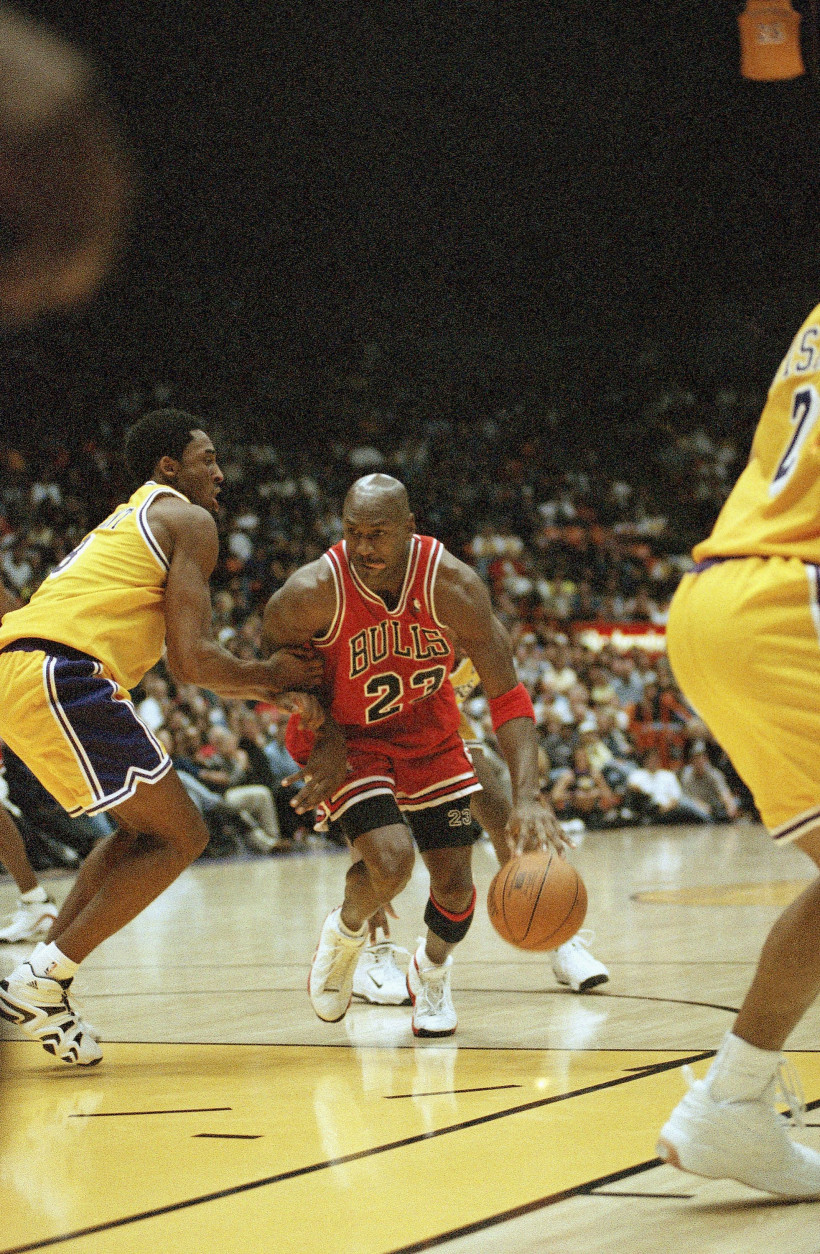 Chicago Bulls Michael Jordan, right, is held up by Los Angeles Lakers Kobe Bryant during the fourth quarter action, Feb. 1, 1998 in Inglewood, California. Lakers routed the Bulls, 112-87. (AP Photo/Kevork Djansezian)
