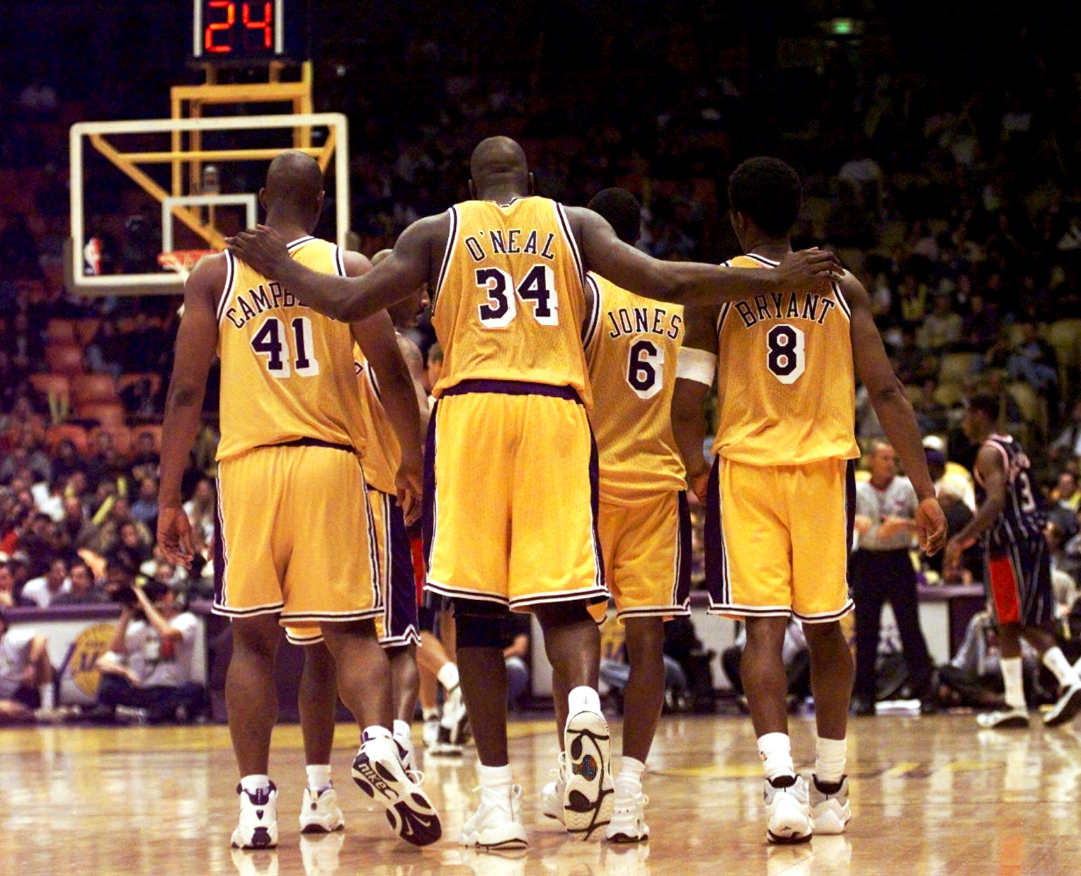 FILE- This Feb. 5, 1999 file photo shows Los Angeles Lakers center Shaquille O'Neal (34) putting his arms around teammates, Elden Campbell (41) and Kobe Bryant (8) as Eddie Jones (6) and Derek Harper walk in front as they return to play the Houston Rockets in the fourth quarter at the Great Western Forum in Inglewood, Calif. O'Neal says on Twitter that he's "about to retire." O'Neal sent a Tweet shortly before 2:45 p.m. saying, "im retiring." It included a link to a 16-second video in which he says, "We did it; 19 years, baby. Thank you very much. That's why I'm telling you first: I'm about to retire. Love you. Talk to you soon." (AP Photo/ Victoria Arocho,File)