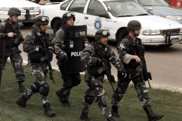 FILE - In this April 20, 1999 file photo members of a police SWAT march to Columbine High School in Littleton, Colo., as they prepare to do a final search of the school. Classes are canceled Tuesday, April 20, 2010 at Columbine High School on the anniversary of the 1999 shootings. Twelve students and a teacher died in the shootings before two teenage gunmen committed suicide. (AP Photo/Ed Andrieski, File)
