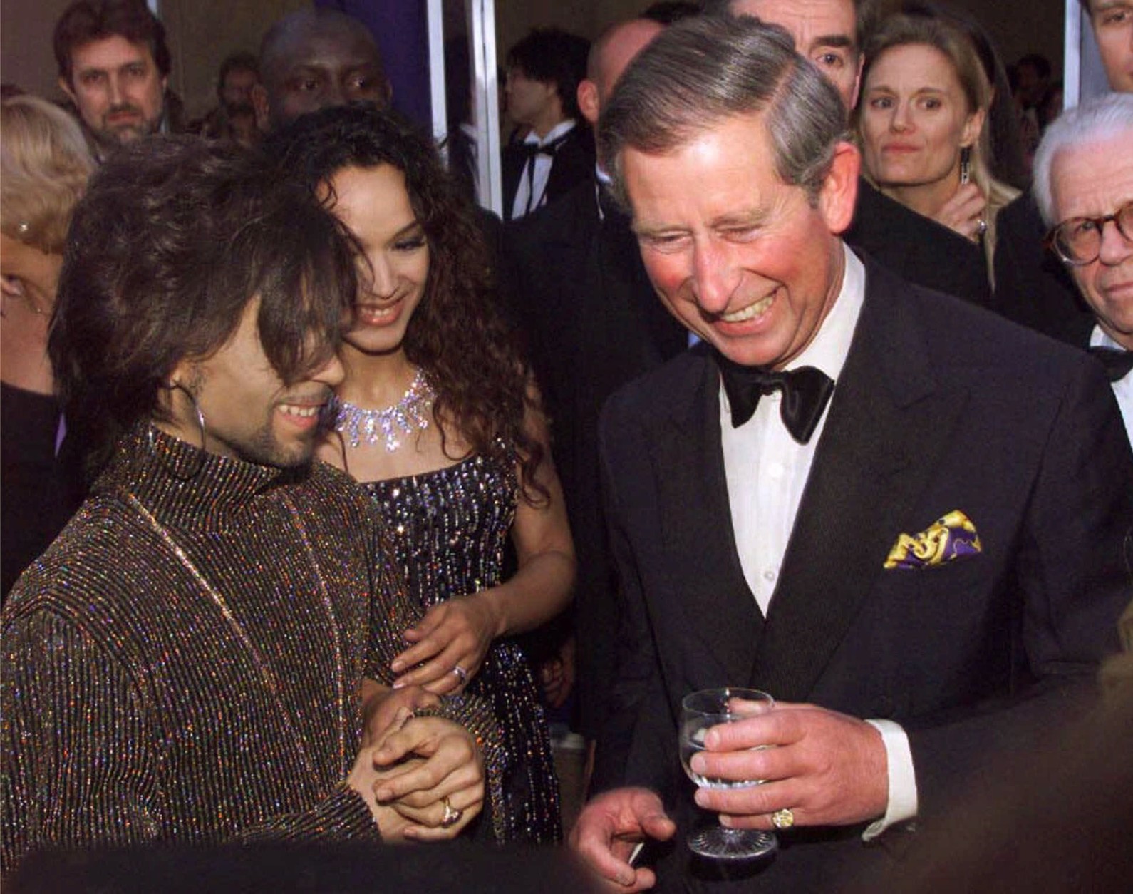 Britain's Prince Charles talks with The Artist, formerly known as Prince, left, at the "Diamonds are Forever" celebration at Syon House, London Wednesday, June 9, 1999. The celebration was to include the unveiling of a multi-million dollar diamond jewelry collection, the first-ever Versace fashion show in Britain and a live performance by Jon Bon Jovi.  The Artist's wife Mayte is at center. (AP Photo/Dave Hogan/pool)