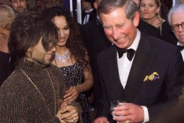 Britain's Prince Charles talks with The Artist, formerly known as Prince, left, at the "Diamonds are Forever" celebration at Syon House, London Wednesday, June 9, 1999. The celebration was to include the unveiling of a multi-million dollar diamond jewelry collection, the first-ever Versace fashion show in Britain and a live performance by Jon Bon Jovi.  The Artist's wife Mayte is at center. (AP Photo/Dave Hogan/pool)