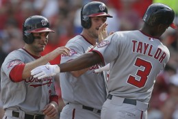 Washington Nationals' Michael Taylor (3) celebrates with teammates Danny Espinosa, left, and Clint Robinson, center, after hitting a three-run home run in the sixth inning of a baseball game against the Cincinnati Reds, Saturday, May 30, 2015, in Cincinnati. (AP Photo/John Minchillo)