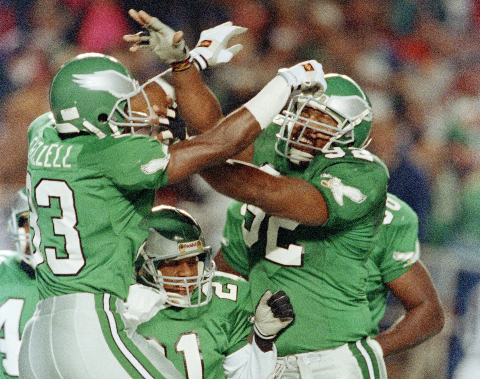 Philadelphia Eagles William Frizzell, left, celebrates his first quarter touchdown after intercepting a pass by Washington Redskins quarterback Jeff Rutledge (not pictured), with teammates Eric Allen, at center, and Reggie White, at right. The action came in the NFL game on Monday, Nov. 12, 1990 at Philadelphia's Veterans Stadium. (AP Photo/Rusty Kennedy)