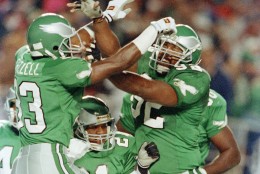 Philadelphia Eagles William Frizzell, left, celebrates his first quarter touchdown after intercepting a pass by Washington Redskins quarterback Jeff Rutledge (not pictured), with teammates Eric Allen, at center, and Reggie White, at right. The action came in the NFL game on Monday, Nov. 12, 1990 at Philadelphia's Veterans Stadium. (AP Photo/Rusty Kennedy)