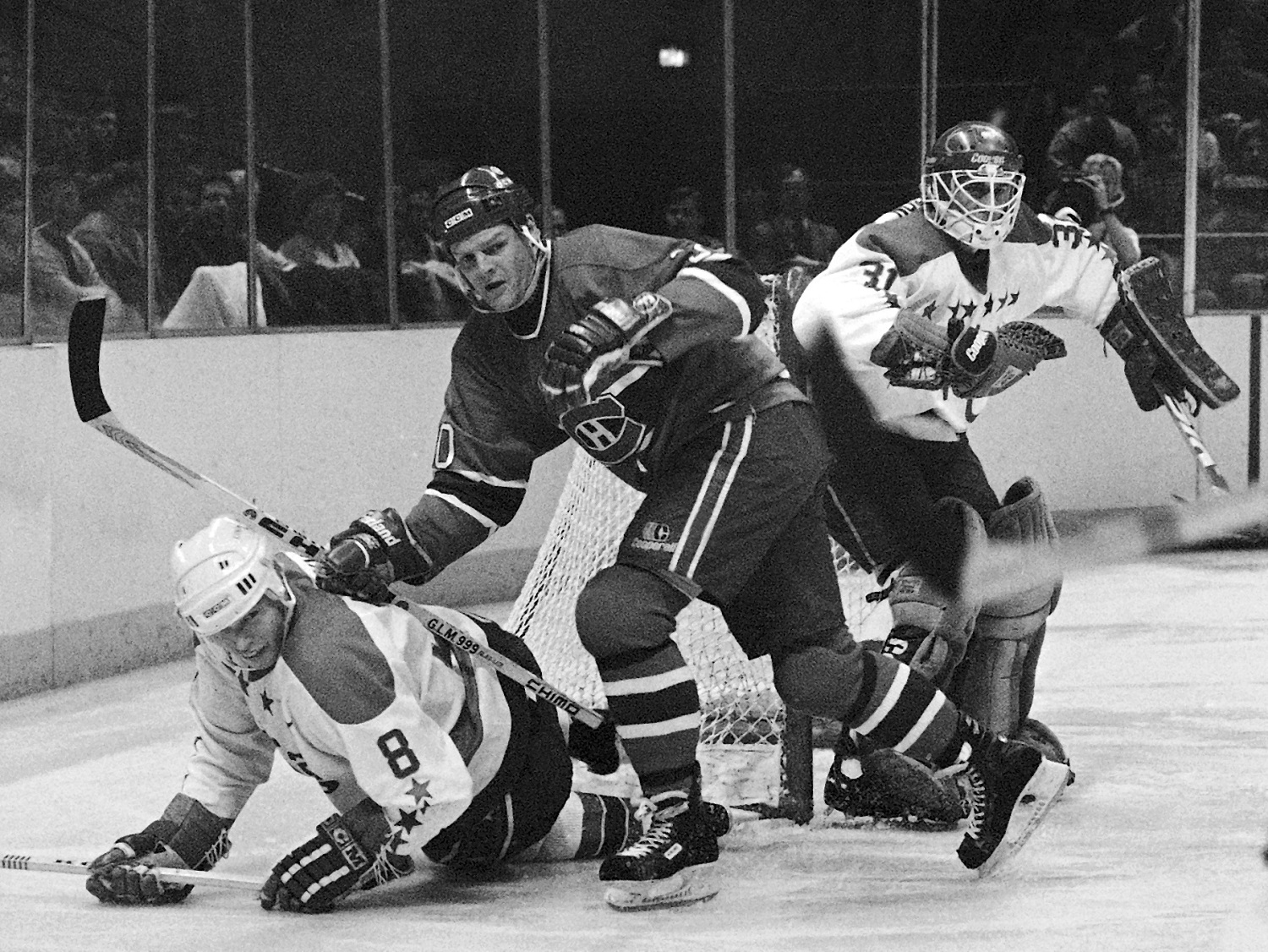 FILE - In this Dec. 6, 1986, file photo, Montreal Canadiens' Chris Nilan, center, shoves Washington Capitals' Larry Murphy to the ice during the first period of an NHL hockey game at the Capital Centre in Landover, Md. Nilan had a far greater fight than one on the ice. He battled herioin and alcohol addiction long after his career as one of the NHL's top brawlers. His life is documented in the upcoming documentary "The Last Gladiators." (AP Photo/Joe Giza, File)