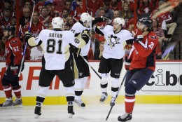 Pittsburgh Penguins' Kris Letang, second from right, celebrates his goal with Evgeni Malkin (71), from Russia, and Miroslav Satan (81), from Slovakia, as Washington Capitals defensemen Mike Green, left, and Shaone Morrisonn (26) skate past during the second period of Game 7 of an NHL hockey second-round playoff series, Wednesday, May 13, 2009, in Washington. The Penguins won 6-2.(AP Photo/Nick Wass)
