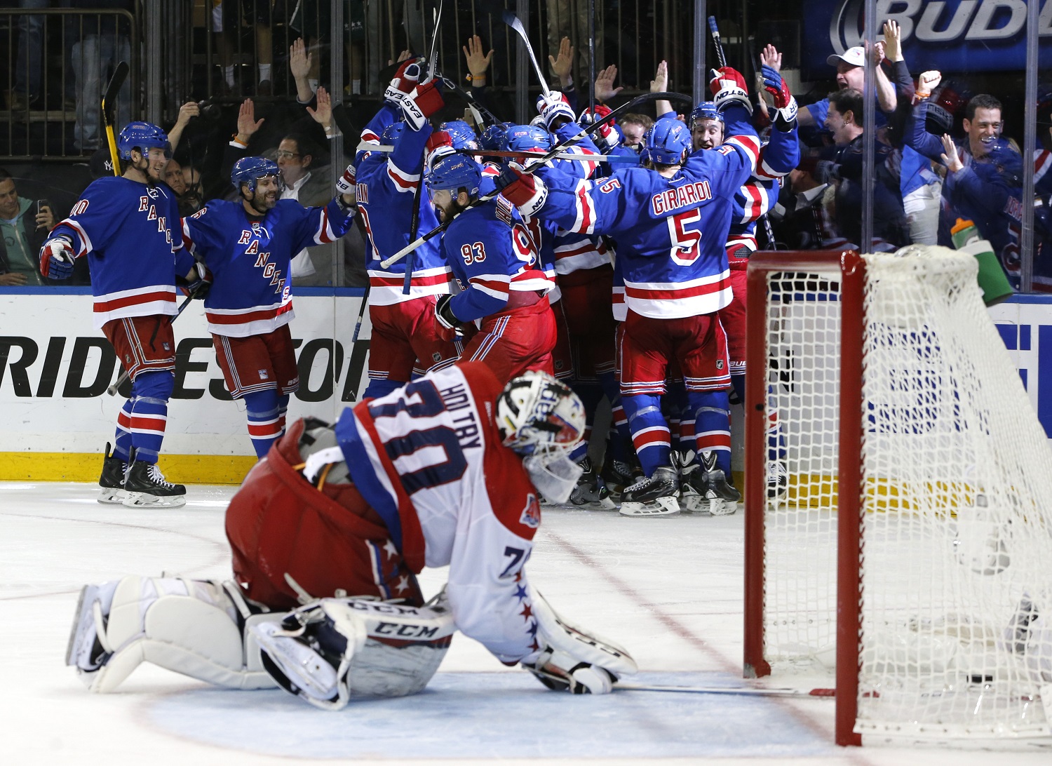 FILE - In this May 13, 2015, file photo, the New York Rangers celebrate the game winning goal by center Derek Stepan (21) against the Washington Capitals as Capitals goalie Braden Holtby looks at the puck in the net in overtime of Game 7 of the Eastern Conference semifinals during the NHL hockey Stanley Cup playoffs in New York. The Rangers won 2-1. The NHL's final four teams are 19-5 at home in the playoffs.  (AP Photo/Kathy Willens, File)