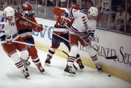 New York Rangers defenseman Normand Rochefort (5) gains the edge against Washington Capitals defenseman Neil Sheehy (15) as they battle for the puck during the Rangers-Capitals Stanley Cup playoff game in New York, Saturday, April 21, 1990. The Capitals beat the Rangers 6-3 to even the series at one game a piece. (AP Photo/Ed Bailey)