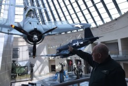 A newly installed SBD-4 Dauntless Dive Bomber hangs form the ceiling of the Leatherneck Gallery. The bomber would be tilted even steeper in action (WTOP/ Kristi King)