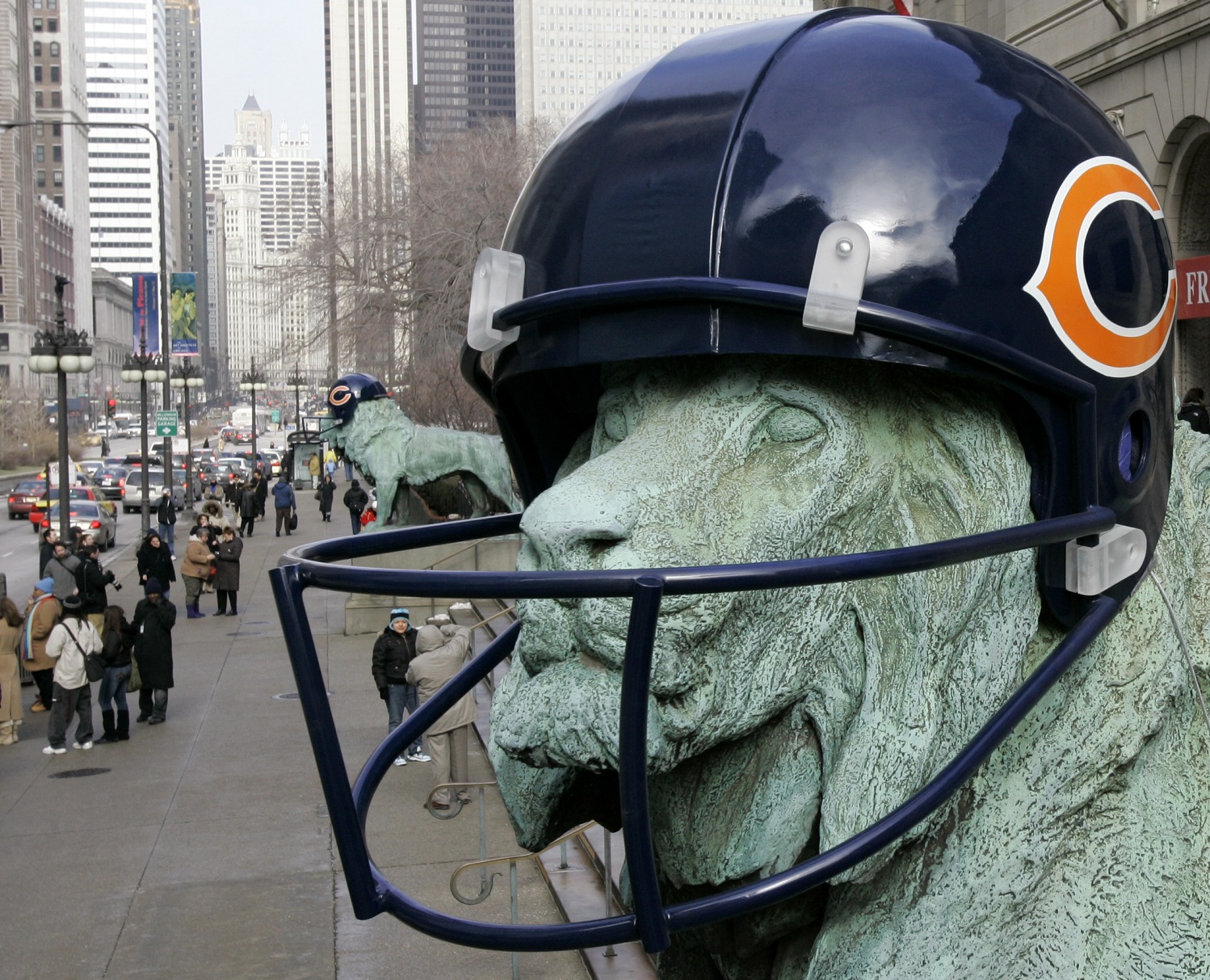Visitors pose for photos with the bronze lions outside the Art Institute of Chicago, Thursday, Feb. 1, 2007. The lions were fitted with oversized helmets to support the Chicago Bears and Super Bowl Festivities. The Bears will play the Indianapolis Colts in Super Bowl XLI on Sunday, Feb. 4th.   (AP Photo/Charles Rex Arbogast)