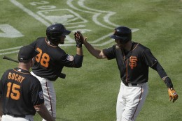 San Francisco Giants' Hunter Pence, right, celebrates with Miguel Olivo (98) and manager Bruce Bochy (15) after hitting a home run against the Oakland Athletics during the fourth inning of a spring training baseball game in Scottsdale, Ariz., Monday, March 21, 2016. (AP Photo/Jeff Chiu)