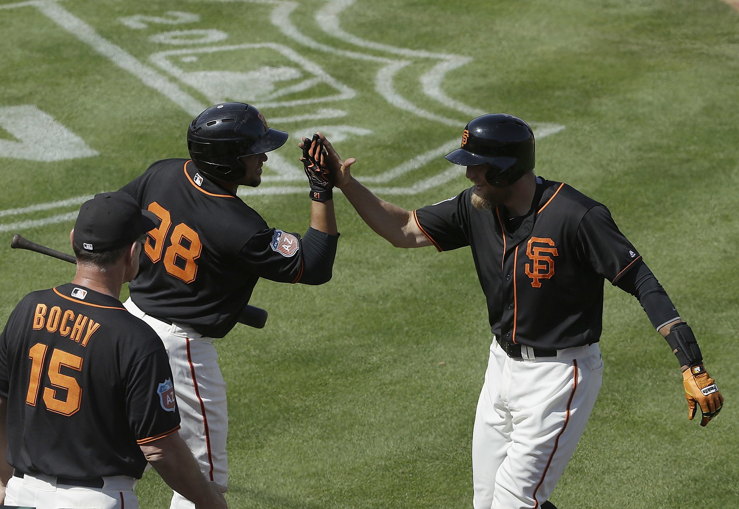 San Francisco Giants' Hunter Pence, right, celebrates with Miguel Olivo (98) and manager Bruce Bochy (15) after hitting a home run against the Oakland Athletics during the fourth inning of a spring training baseball game in Scottsdale, Ariz., Monday, March 21, 2016. (AP Photo/Jeff Chiu)