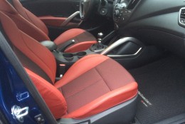 The interior of the Hyundai Veloster R-Spec has nice interior touches, such as the leather-wrapped steering wheel and shift knob, red. Even the seatbelts are red. (WTOP/Mike Parris)