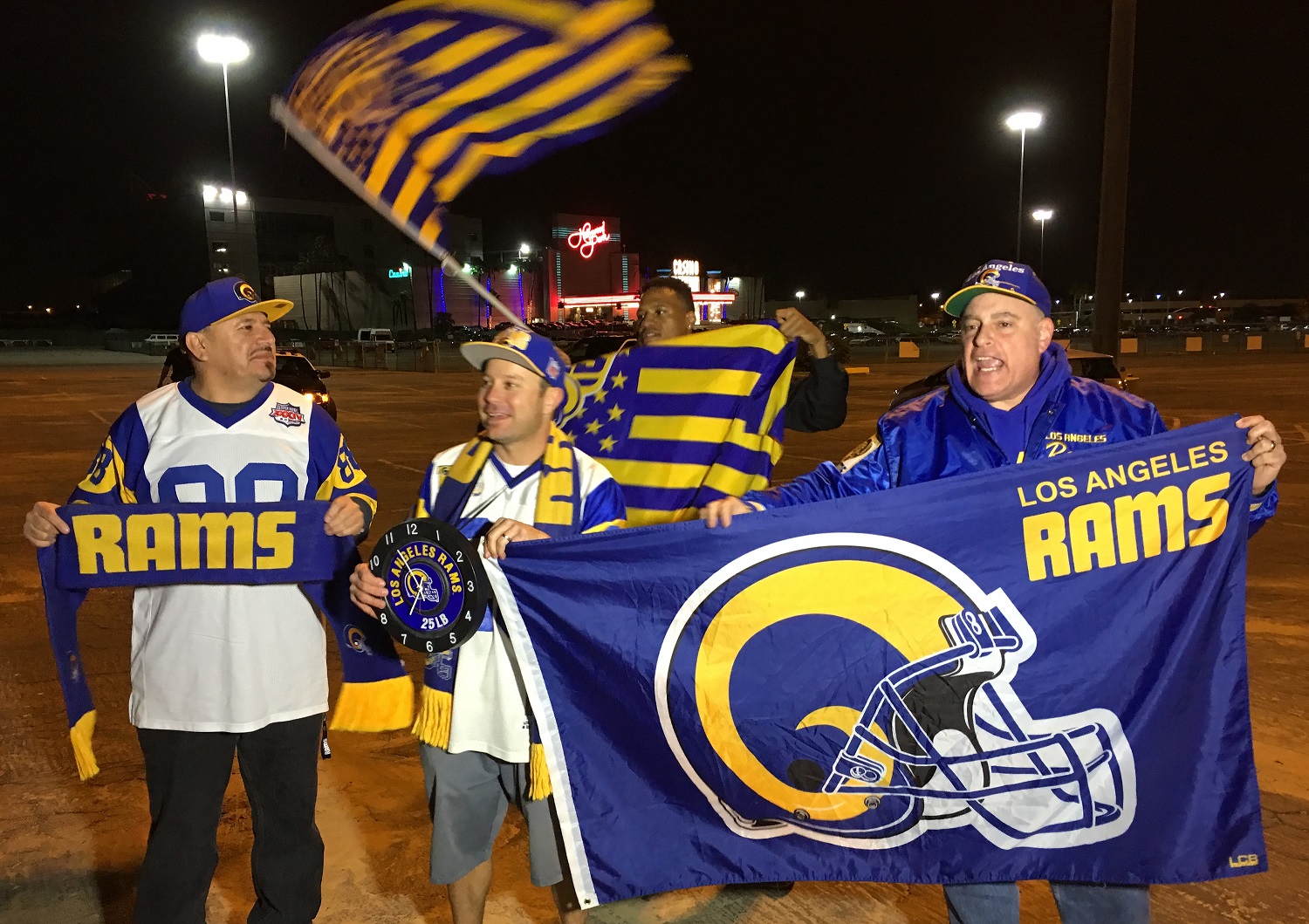 Football fans cheer for the return of the Rams to Los Angeles on the site of the old Hollywood Park horse-racing track in Inglewood, Calif., on Tuesday, Jan. 12, 2016. NFL owners voted Tuesday night to allow the St. Louis Rams to move to a new stadium at the site just outside Los Angeles, and the San Diego Chargers will have an option to share the facility. (AP Photo/Damian Dovarganes)