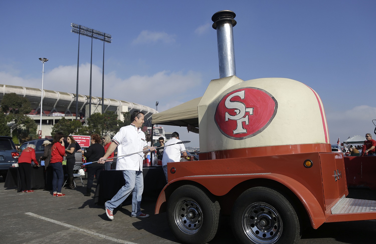 Jeff Taurian cooks a pizza in the Rolling In Dough mobile pizza truck from Woodside, Calif., with a San Francisco 49ers logo painted on the side, in the Candlestick Park parking lot before an NFL football game between the San Francisco 49ers and the Carolina Panthers in San Francisco, Sunday, Nov. 10, 2013. (AP Photo/Jeff Chiu)