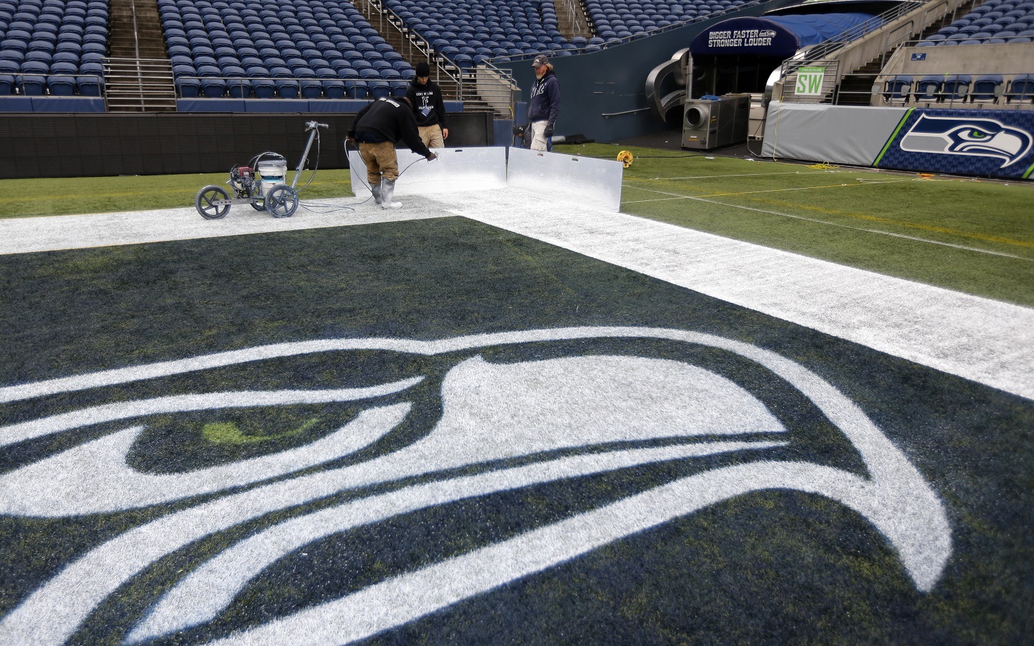Members of the CenturyLink Field stadium operations team an end zone line near the Seattle Seahawks logo Tuesday, Jan. 14, 2014 as they prepare the field for Sunday's NFL football NFC championship between the Seattle Seahawks and the San Francisco 49ers in Seattle. (AP Photo/Ted S. Warren)