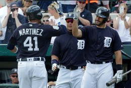 After hitting a home run in the first inning against the New York Yankees, Detroit Tigers' Victor Martinez (41) is greeted by teammates Miguel Cabrera, center, and J.D. Martinez, right, in a spring training baseball game, Thursday, March 31, 2016, in Lakeland, Fla. (AP Photo/John Raoux)