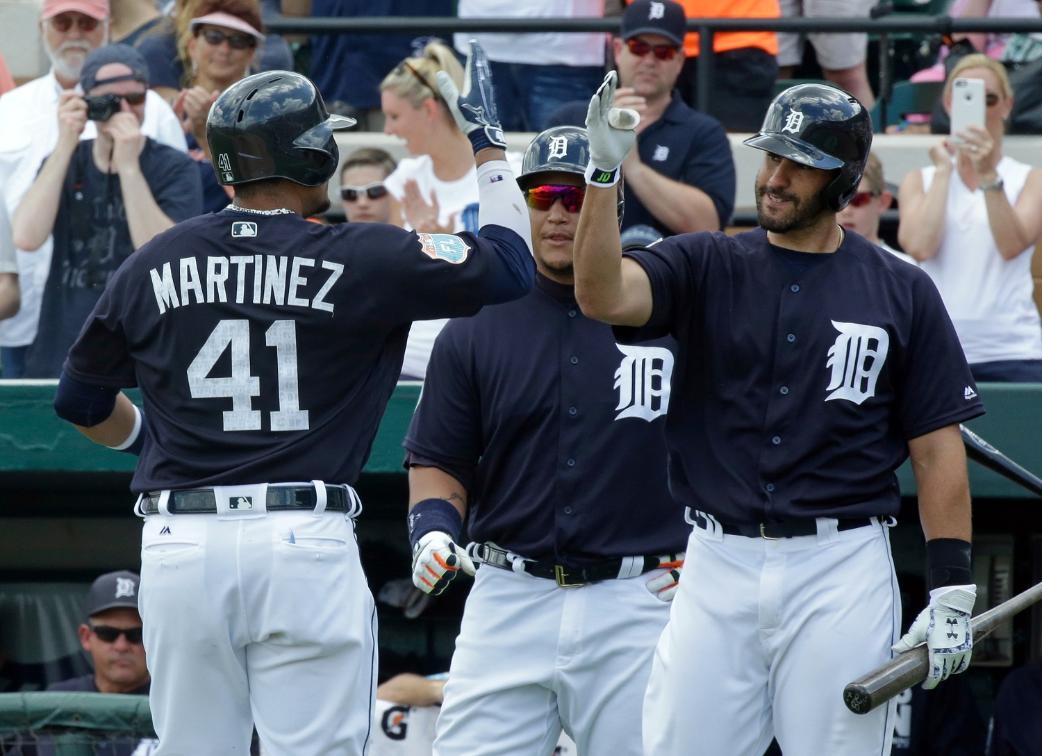 After hitting a home run in the first inning against the New York Yankees, Detroit Tigers' Victor Martinez (41) is greeted by teammates Miguel Cabrera, center, and J.D. Martinez, right, in a spring training baseball game, Thursday, March 31, 2016, in Lakeland, Fla. (AP Photo/John Raoux)