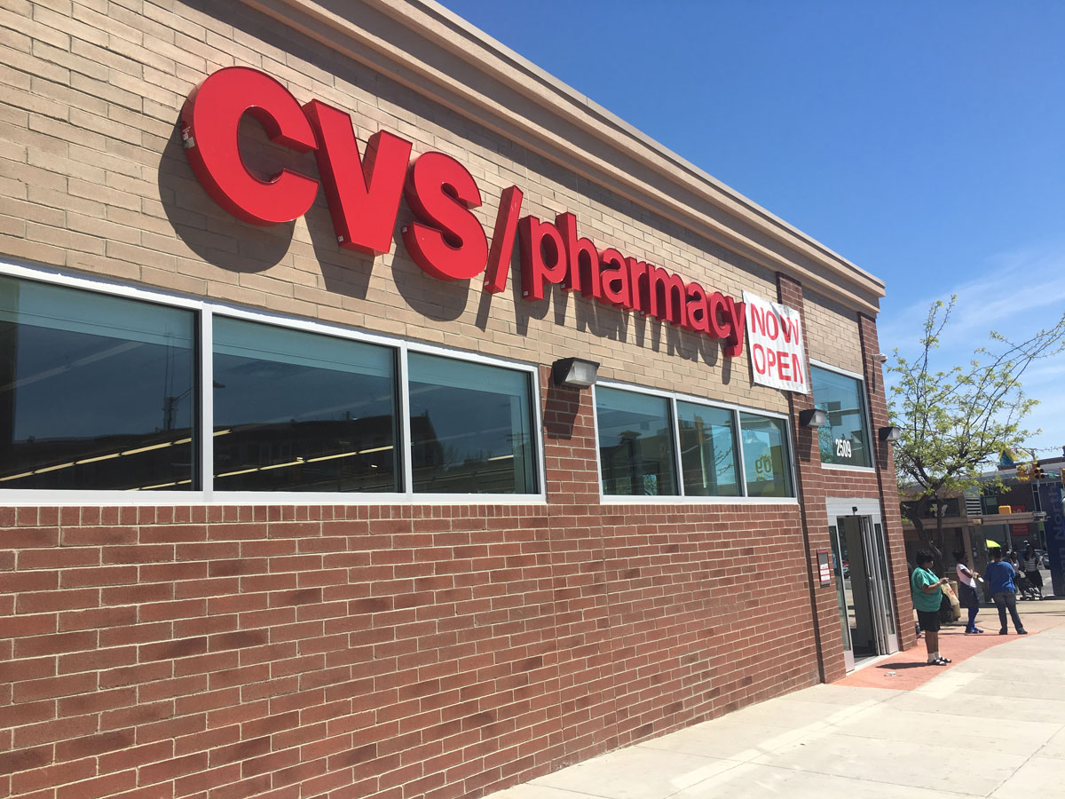 A "now open" sign is seen on the CVS Pharmacy that was destroyed during the Baltimore riots in April 2015. (WTOP/Mike Murillo)