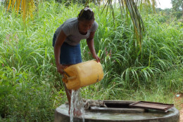 Before having the new well equipped with a pump, community members had to pull water up with a bucket and rope. (Photo courtesy of TheWaterProject.org)