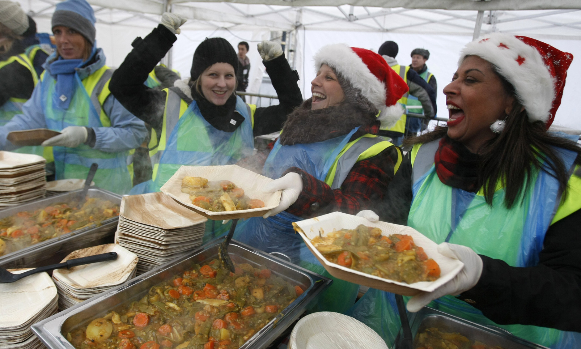 Volunteers serve lunch of vegetable curry to the public during an event to highlight  food waste in Trafalgar Square, London Wednesday Dec. 16, 2009. Campaigners, charities and prominent supporters will serve a free lunch to 5000 members of the public to draw attention to the problem of food waste.  The free lunch will be made entirely out of fresh food that would otherwise have been thrown away in an attempt to highlight how much food gets wasted every day  and the impact that has on the environment. It is estimated that rich countries like the UK currently waste up to half their food supplies.  (AP Photo/Alastair Grant)