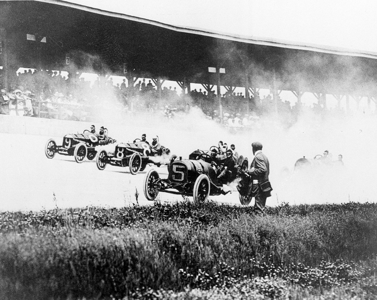 Drivers speed into the first turn on the Brickyard in the first Indianapolis 500-mile race in Indianapolis, Ind., Thursday, May 30, 1911.  The drivers from left are, Will Jones (9) driving a Case; Joe Jagersberger (8) in a Case; and Louis Disbrow (5) in a Pope-Hartford. Ray Harroun won the race at an average speed of 74.602 miles per hour.  (AP Photo)