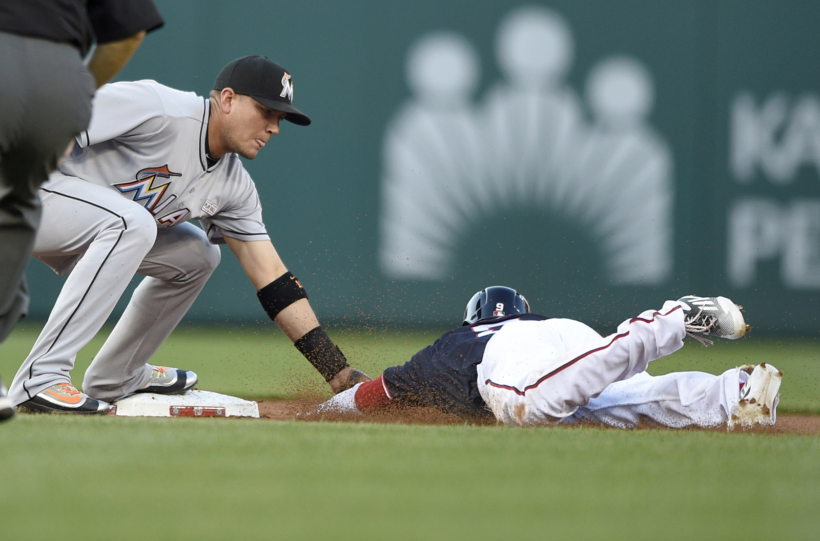 Washington Nationals' Ben Revere, right, is out while trying to steal second by Miami Marlins second baseman Miguel Rojas, left, during the first inning of a baseball game, Friday, May 13, 2016, in Washington. (AP Photo/Nick Wass)