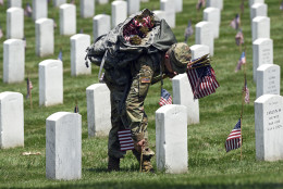 Members of the Old Guard place flags in front of every headstone at Arlington National Cemetery in Arlington, Va., Thursday, May 26, 2016. Soldiers were to place nearly a quarter of a million U.S. flags at the cemetery as part of a Memorial Day tradition. (AP Photo/Susan Walsh)