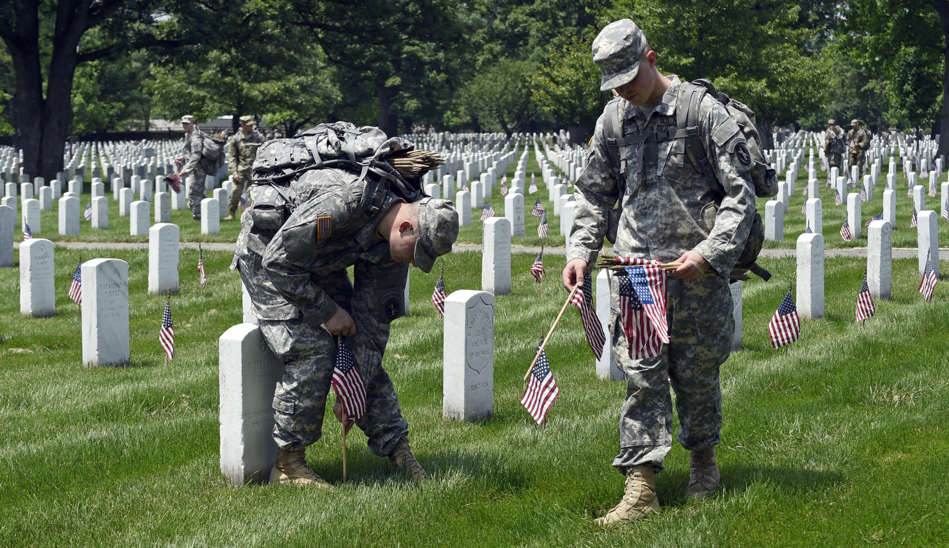 Members of the Old Guard Pvt. Brandon Hyer, left, from Kansas City, Kan., and Pvt. Brad Dixon of Baltimore, Md., place flags in front of every headstone at Arlington National Cemetery in Arlington, Va., Thursday, May 26, 2016. Soldiers were to place nearly a quarter of a million U.S. flags at the cemetery as part of a Memorial Day tradition. (AP Photo/Susan Walsh)