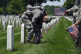 Members of the Old Guard Pvt. Brandon Hyer, left, from Kansas City, Kan., and Pvt. Brad Dixon of Baltimore, Md., place flags in front of headstones at Arlington National Cemetery in Arlington, Va., Thursday, May 26, 2016. Soldiers were to place nearly a quarter of a million U.S. flags at the cemetery as part of a Memorial Day tradition. (AP Photo/Susan Walsh)
