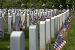 Members of the Old Guard with the Washington Memorial in the back, place flags in front of every headstone at Arlington National Cemetery in Arlington, Va., Thursday, May 26, 2016. Soldiers were to place nearly a quarter of a million American flags at the cemetery as part of a Memorial Day tradition. (AP Photo/Jose Luis Magana)