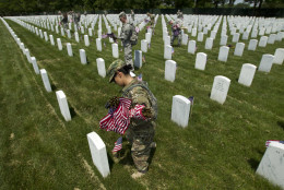 Members of the Old Guard place flags in front of every headstone at Arlington National Cemetery in Arlington, Va., Thursday, May 26, 2016. Soldiers were to place nearly a quarter of a million American flags at the cemetery as part of a Memorial Day tradition. ( AP Photo/Jose Luis Magana)