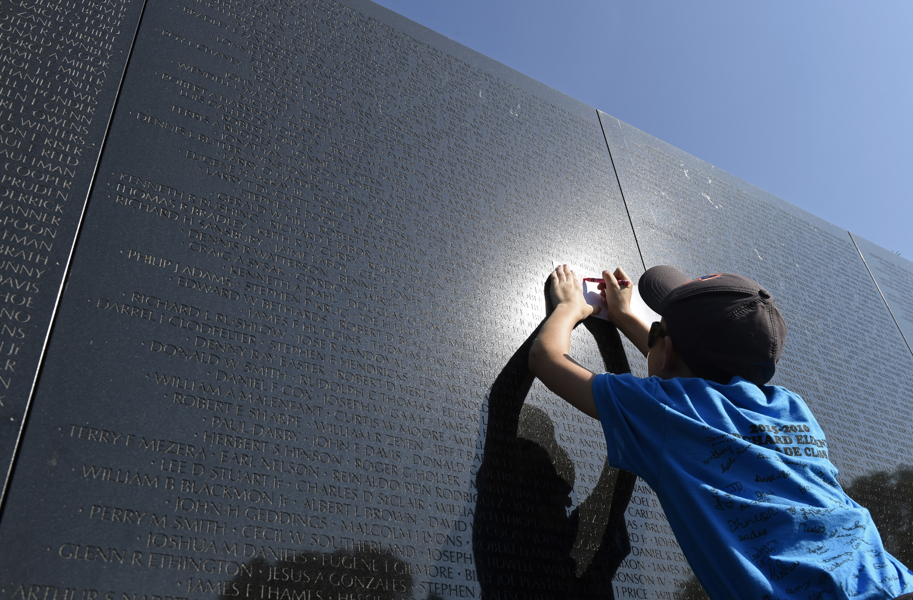 Zack Drake, 11, from Crab Orchard, W. Va., takes a rubbing of a name from the Vietnam War Memorial in Washington, Friday, May 27, 2016. The visit was part of the Crab Orchard Elementary School visit to Washington, on the start  of the Memorial Day weekend. (AP Photo/Susan Walsh)