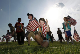 Throngs of scouts rush to place thousands of flags on veteran's graves at Brig. Gen. William C. Doyle Veterans Memorial Cemetery in honor of Memorial Day, Friday, May 27, 2016, in Wrightstown N.J. (AP Photo/Mel Evans)