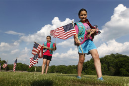 Twin Girl Scouts Sarah and Megan Lontoc, 10, place flags as the scouts placed thousands of flags on veteran's graves at Brig. Gen. William C. Doyle Veterans Memorial Cemetery in honor of Memorial Day, Friday, May 27, 2016, in Wrightstown N.J. (AP Photo/Mel Evans)